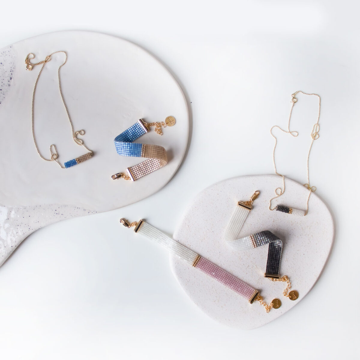 Elegant bracelets and necklaces displayed on a white ceramic plate.